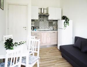 cocina y sala de estar con sofá y mesa en HOTEL RESIDENCE VILLA NINA, en Spotorno
