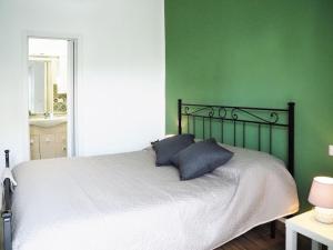 a bedroom with green walls and a bed with two pillows at HOTEL RESIDENCE VILLA NINA in Spotorno
