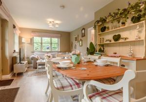 Il comprend une cuisine et une salle à manger avec une table et des chaises en bois. dans l'établissement Little Broad, à Rollesby