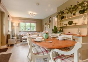 a kitchen and dining room with a wooden table and chairs at Little Broad in Rollesby