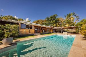 uma piscina em frente a uma casa em Villa Ô Pieds Nus 180m2 4 chambres piscine jardin tropical parking privé em Saint-Leu