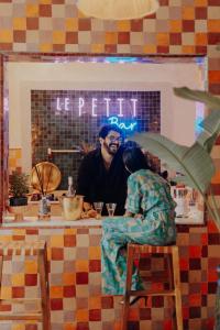un homme et une femme assis dans un bar dans l'établissement Le Petit Kenzara & magical rooftop, à Marrakech