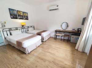 een slaapkamer met 2 bedden, een bureau en een tafel bij Sea Mountain Boutique Hotel & Villa in Vung Tau