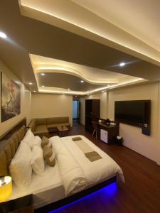 um quarto com uma cama grande e um sofá em XCELSIOR HOTEL & SPA em Shillong