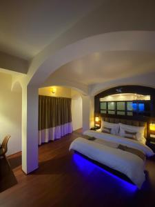 a large bedroom with a large bed with a blue light at XCELSIOR HOTEL & SPA in Shillong