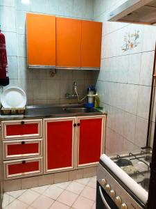 a kitchen with orange cabinets and a sink at Everest Hotel Apartments in Sharjah