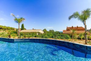 a large swimming pool with blue tile and palm trees at SELECT' - T2 à Saint-Clair au Lavandou dans une résidence neuve avec piscine - 180SUD-B12 in Le Lavandou