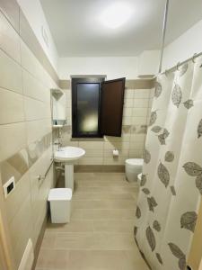 een badkamer met 2 toiletten, een wastafel en een douche bij Sogni d'insonnia 