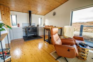 a living room with a chair and a stove at The Boathouse in Tomich