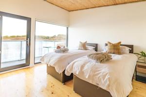 two beds in a bedroom with a large window at The Boathouse in Tomich