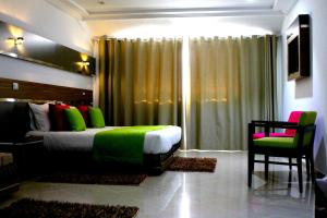 Un dormitorio con una cama verde y una silla en Marina Prestige Tabarka en Tabarka