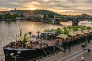 un barco en un río con un restaurante en él en Cozy Homestay at Andel Prague, en Praga