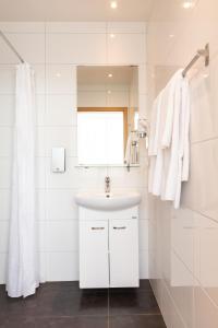 a white bathroom with a sink and a window at Hotel Selfoss in Selfoss