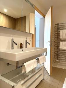 a bathroom with a white sink and a shower at Pineview Waldhaus in Flims