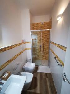 ein Badezimmer mit zwei Waschbecken, einer Dusche und einem WC in der Unterkunft B&B Villa Mariotta in Amantea