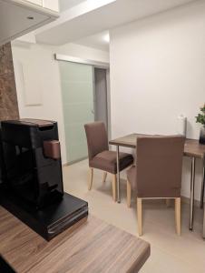 un salon avec une table, des chaises et une télévision dans l'établissement Bietigheimer Hideaway - Modern und Gemütlich, à Bietigheim 5 autres photos