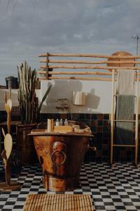La salle de bains est pourvue d'une baignoire en cuivre et d'un lavabo. dans l'établissement Le Petit Kenzara & magical rooftop, à Marrakech