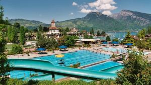 uma grande piscina com montanhas ao fundo em Wohnung mit grossartiger Seesicht und Balkon em Spiez