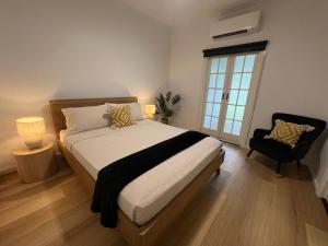 a bedroom with a bed and a chair and a window at Sans Souci Apartments in Ingham