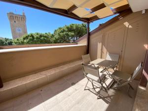 two chairs and a table on a balcony with a clock tower at Charming Apts - Via Pastrengo in Porto Recanati