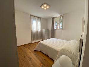 a white bedroom with a bed and a window at Charming Apts - Via Pastrengo in Porto Recanati