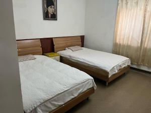 um quarto com duas camas e uma foto na parede em Gana's Guest House and Tours em Ulan Bator