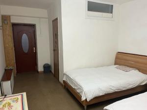 1 dormitorio con 1 cama y puerta con ventana en Gana's Guest House and Tours, en Ulán Bator