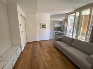 a living room with a couch and wooden floors at Charming Apts - Via Pastrengo in Porto Recanati
