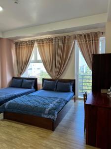 - une chambre avec 2 lits et une fenêtre dans l'établissement Minh Trang Motel, à Chau Doc