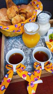 a table with three cups of coffee and a basket of bread at CAMPING le fruit de la passion in Saint-Louis