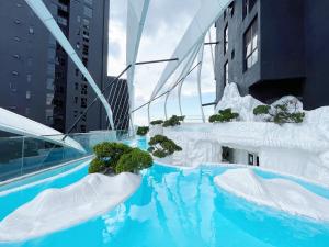 a swimming pool with icebergs and plants in a city at Nj Homestay at Arte Mont Kiara in Kuala Lumpur