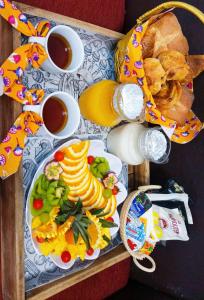 a table with a plate of food and cups of tea at CAMPING le fruit de la passion in Saint-Louis