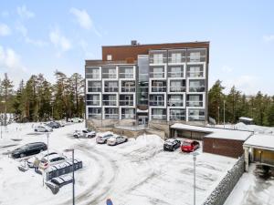 a large building with cars parked in a parking lot at Hiisi Homes Porvoo Toukovuori in Porvoo