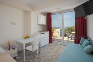 a room with a bed and a kitchen with a table at Bellino Apartments "Adults Only" in Hersonissos