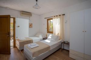 1 dormitorio con 2 camas y ventana en Bellino Apartments "Adults Only" en Hersonissos
