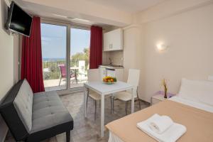 a bedroom with a bed and a table and a kitchen at Bellino Apartments "Adults Only" in Hersonissos