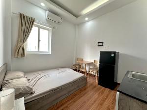 een slaapkamer met een bed, een tafel en een raam bij Taibo house 2 in Ho Chi Minh-stad