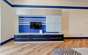 ein Wohnzimmer mit einem TV und einer blauen Wand in der Unterkunft Sonia in Novigrad Istria