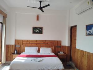 a bedroom with a bed with a ceiling fan at Hotel CM Palace - Pure Vegetarian 