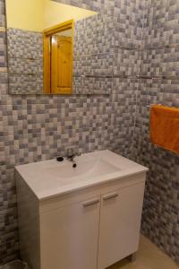 uma casa de banho com um lavatório branco e um espelho. em Monkey's Guest House - Appartement roof top terrasse privée vue sur mer em Tamraght Ouzdar