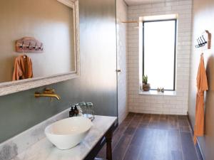een badkamer met een wastafel en een spiegel bij Lodge Damaraland in Khorixas +36 foto's