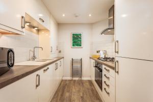 エアにあるBay View - Donnini Apartmentsのキッチン(白いキャビネット、シンク、コンロ付) +20枚の写真