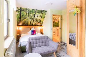 1 dormitorio con cama, sofá y ventana en Berghotel Talblick, en Holzhau