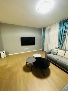 ein Wohnzimmer mit einem Sofa und 2 Tischen in der Unterkunft Sarajevo Exclusive Apartment with Free garage in Sarajevo