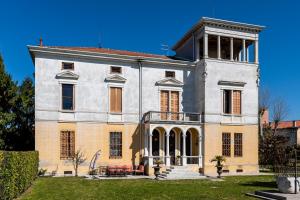 um grande edifício branco e laranja num quintal em Villa Liberty a soli 20km da Venezia em Mira