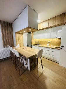 eine Küche mit einem Holztisch und weißen Schränken in der Unterkunft Sarajevo Exclusive Apartment with Free garage in Sarajevo