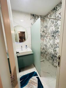 ein Bad mit einem Waschbecken und einem Spiegel in der Unterkunft Sarajevo Exclusive Apartment with Free garage in Sarajevo