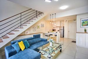 a living room with a blue couch and a staircase at Arte Mont Kiara Free Parking, Kuala Lumpur in Kuala Lumpur