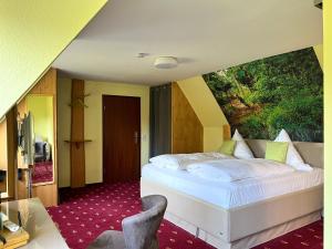 1 dormitorio con 1 cama con una pintura en la pared en Berghotel Talblick en Holzhau