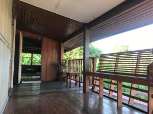 a porch with wooden railing and a table and chairs at BS.homestay mindfulness and well-being in Phra Nakhon Si Ayutthaya